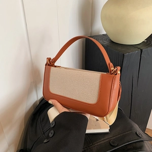 Detail of vintage patchwork crossbody bag with brown leather and beige canvas texture