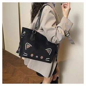 Close-up of stylish black tote bag featuring a minimalist cartoon cat pattern on textured PU leather