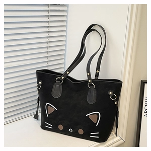 Detail of cute cat tote bag featuring suede texture and gold hardware on white ledge