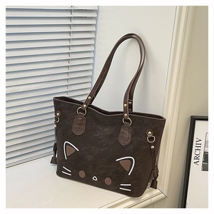 Detail of cute cat face design on dark brown PU leather tote bag with tassels