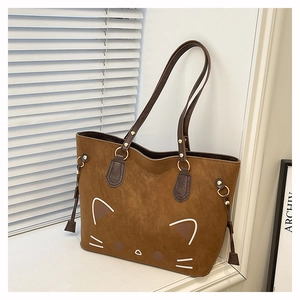 Detail of cute white cartoon cat print on a brown suede tote bag with metal rings