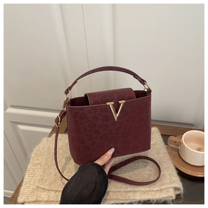 Détail du sac à main bordeaux à motif léopard avec boucle en V dorée chic
