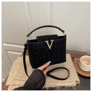 Détail du sac à main léopard avec boucle dorée en V et texture en velours élégante et chic