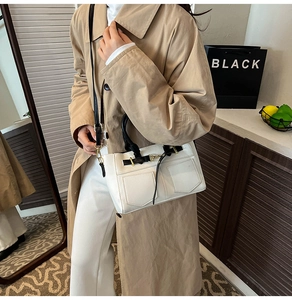 Detail of contrast stitch minimalist square handbag with gold hardware and top handle