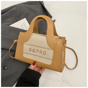 Detail of two-tone tote bag featuring BEPRO embroidery and elegant gold hardware accents