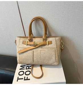 Detail of vintage canvas and brown leather crossbody bag with golden metal buckles