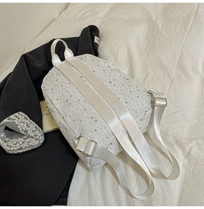 Detail of white nylon backpack with star print and adjustable fabric shoulder straps