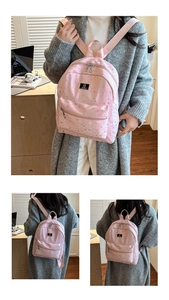 Pink school backpack with star print featuring a front zipper pocket and metal brand tag