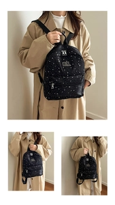 Detail view of black backpack featuring white star patterns and premium metal zippers