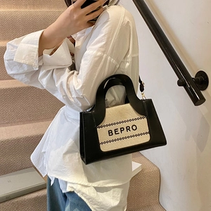 Minimalist black and white BEPRO tote bag with letter print shown in a stylish urban setting