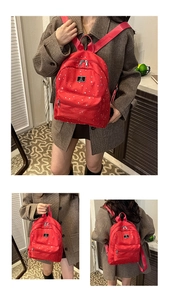Detail of red nylon backpack with silver star patterns and dual metal zippers