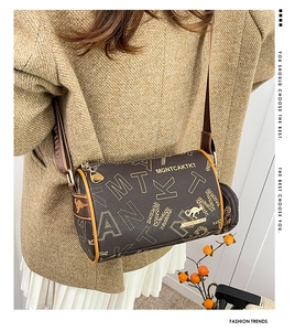 Detail of dark brown Boston bag with golden letter print and kangaroo metal logo