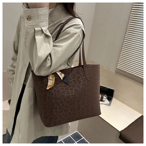 Close-up of brown leopard print suede tote bag featuring a decorative silk scarf handle