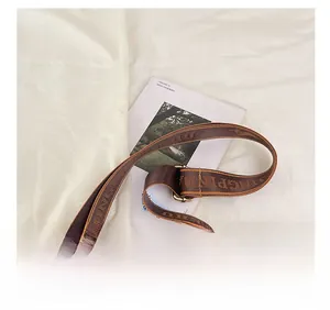 Detail of adjustable jacquard wide strap on a brown letter print crossbody Boston bag