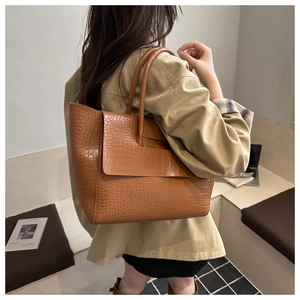 Close-up of a large brown crocodile pattern tote bag featuring premium textures