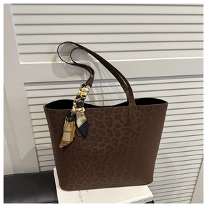 Detailed view of brown leopard embossed tote bag with decorative colorful silk scarf handle