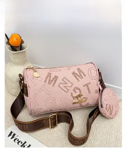 Macro shot of pink lychee textured leather Boston bag with decorative brown lettering