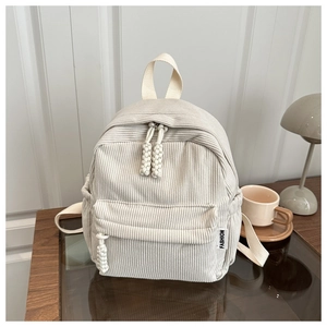 Detail shot of beige corduroy backpack with fashion label and textured front pocket