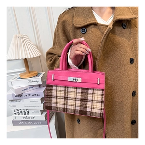 Détail du sac en cuir rose et tissu à carreaux avec fermoir pivotant en métal argenté