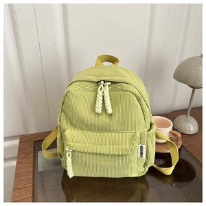 Close-up of the light green corduroy backpack showing texture and side fashion label