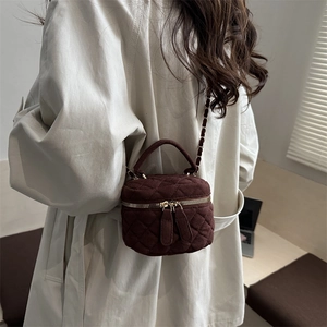 Bolso vanity acolchado marrón con cadena dorada y gabardina beige de moda