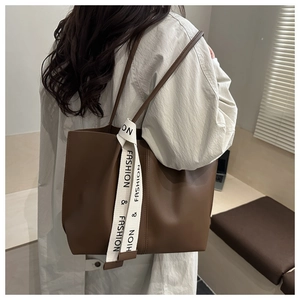 Close-up of a minimalist coffee brown tote bag featuring a stylish fashion ribbon detail
