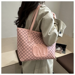 Detail of pink tote bag with brown M pattern and round embossed leather logo patch