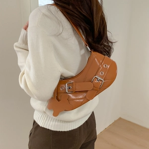 Caramel crescent underarm bag with metal buckle and cute bear pendant shown on model