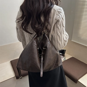 Retro deep brown large capacity faux leather backpack worn by model in minimalist studio