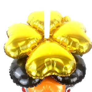 Detail van metallic hartvormige folieballonnen in goud, zwart en oranje bloemmotieven