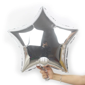 Silver star foil balloon with metallic mirror finish held by hand for party decoration