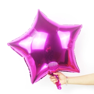Close-up of a hand holding a 24-inch metallic purple star foil balloon for party decor