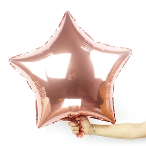 Close-up of a 24 inch rose gold star foil balloon held against a white background