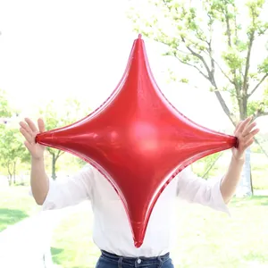 Macro view of large red four-point star foil balloon for festive decoration