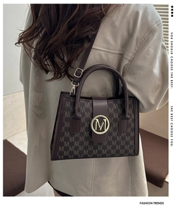 Brown monogram tote bag styled with a beige oversized shirt for a chic commuting look
