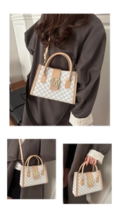 Detail of vintage style tote bag featuring M-print pattern and golden logo clasp