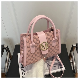 Detail of pink textured leather bag with gold M-logo buckle and monogram pattern