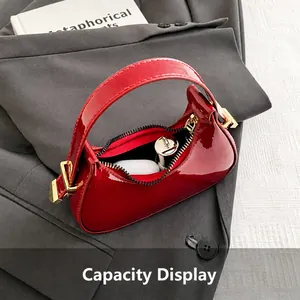 Vue intérieure du sac coquille en cuir verni bordeaux montrant le rangement d'objets