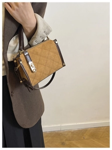Detail of vintage quilted pattern on suede handbag with golden metal turn-lock closure
