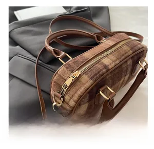 Detailed macro of brown plaid wool boston bag with premium gold metal zipper hardware