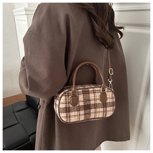Detailed view of the checkered wool texture and leather handle on this Boston handbag