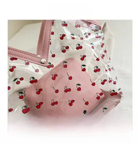 Detail of transparent PVC tote with cherry print and pink leather inner pouch
