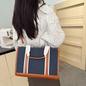 Τσάντα denim tote με αντίθεση και καφέ δερμάτινη επένδυση φορεμένη από μοντέλο για καθημερινή χρήση
