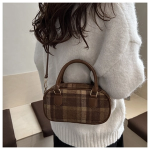 Braune Karo-Zylindertasche an Model mit weißem Strickpullover für Herbst und Winter