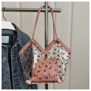 Detail of transparent PVC tote with cherry pattern and pink inner pouch set