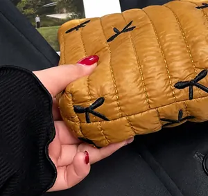 Dettaglio della borsa gialla trapuntata con ricamo a farfalla nera e cuciture precise