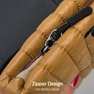 Vista macro di una borsa trapuntata marrone con zip e cuciture dorate a vista