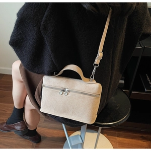 Detailansicht der beige Wildledertasche mit Herz-Reißverschluss und schmalem Gurt