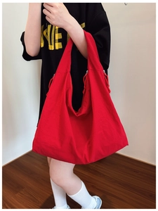Close-up of red large-capacity tote bag with drawstring details on a female model