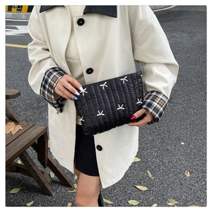 Dettaglio pochette trapuntata in velluto a coste nero con ricamo a farfalla e chiusura zip